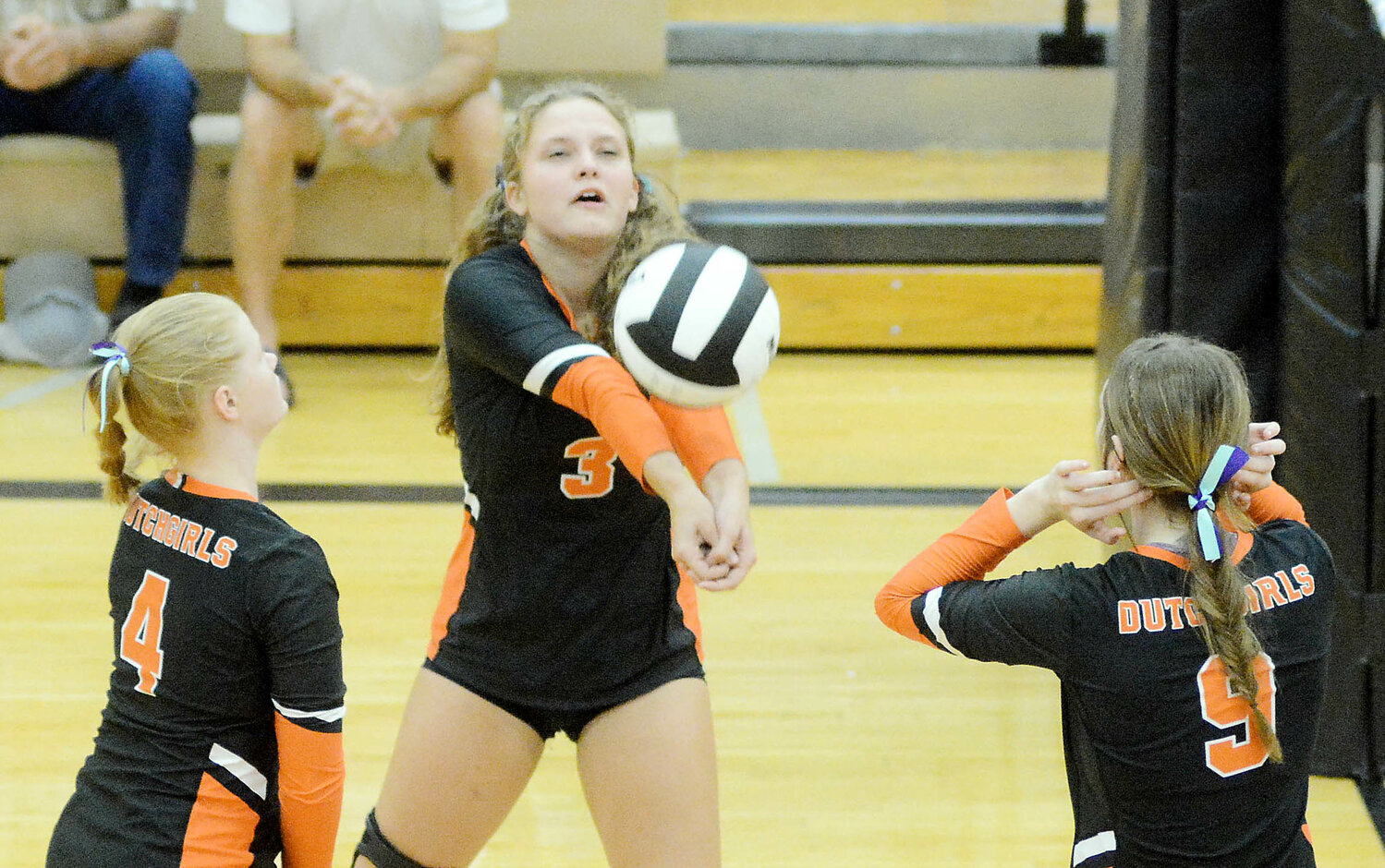Ayla Schmanke (center) bumps the volleyball while Dutchgirl teammates Liz Adams (left) and Mya Vandegriffe (9) converge on the play Monday night during home volleyball action at Owensville High School against Rolla.